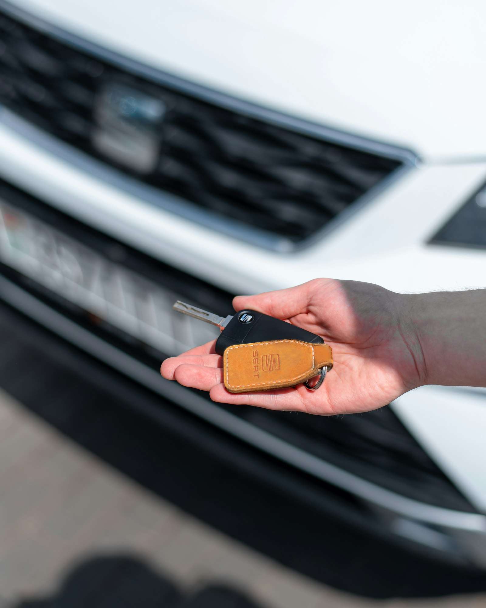A person holding a car key, representing a car loan