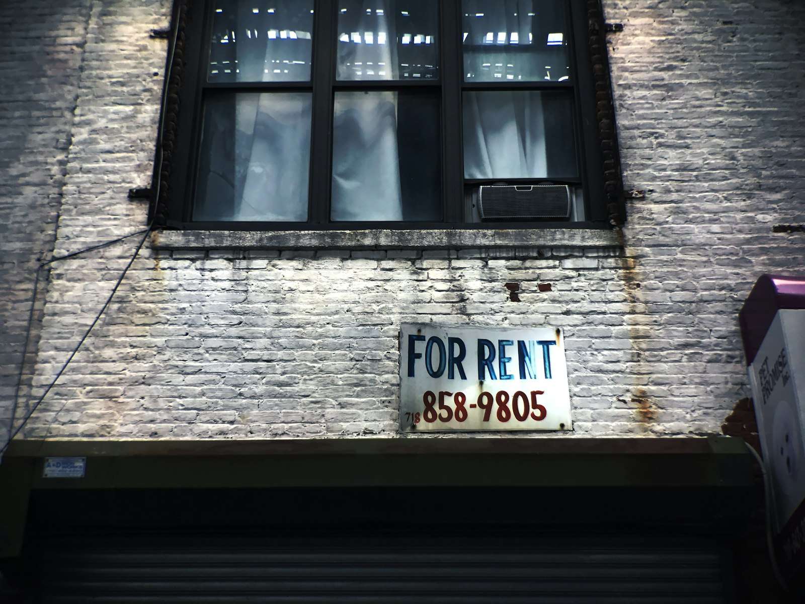 A for rent sign on a building window, representing an investment property