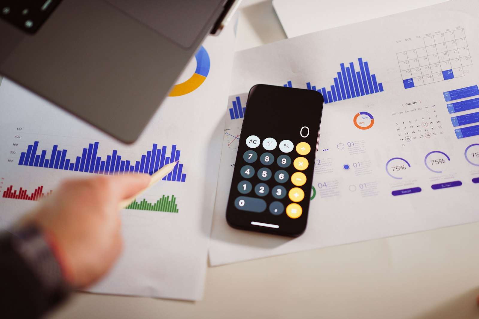 A calculator on a table next to a laptop, representing calculating bonus tax and Division 293